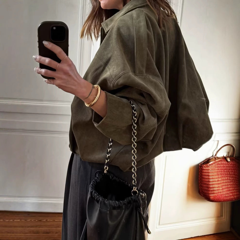 Woman wearing a brown ultra-loose faux suede bomber jacket, side view