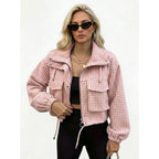 Woman wearing a pink houndstooth cropped utility jacket, front view