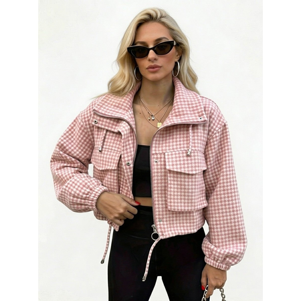 Woman wearing a pink houndstooth cropped utility jacket, front view
